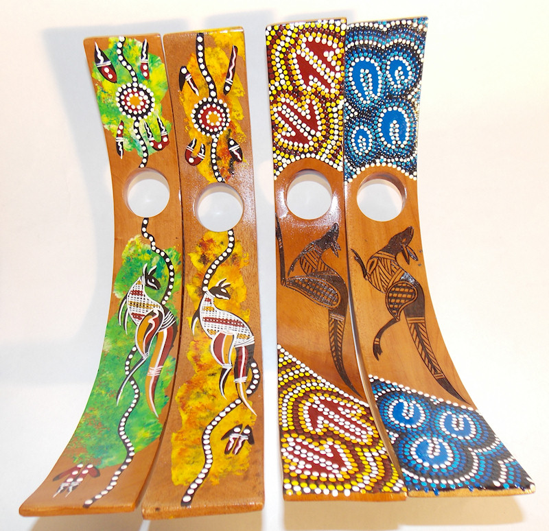 A selection of C-shaped wine bottle holders decorated with Aboriginal art