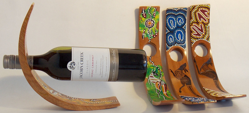 C-shaped wine bottle holders decorated in Aboriginal contemporary art and traditional dot art style 
